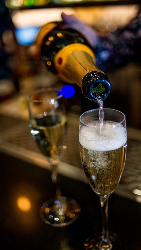 Bartender som häller upp ett glas champagne på vår japanska restaurang på Kungsholmen i Stockholm